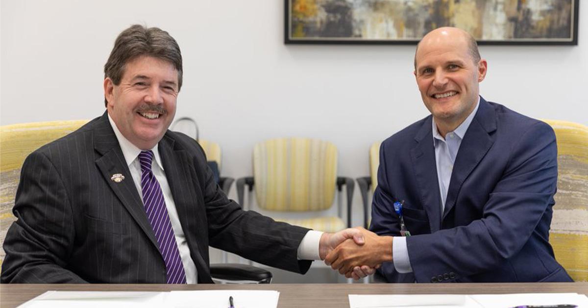 North Alabama Medical Center Chief Executive Officer Russell Pigg shakes hands with University of North Alabama President Ken Kitts.